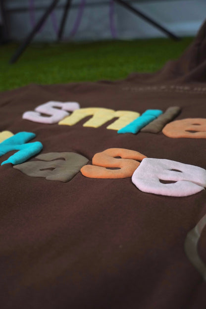 "Smiley Phases" Hoodie - Cosmic Brownie
