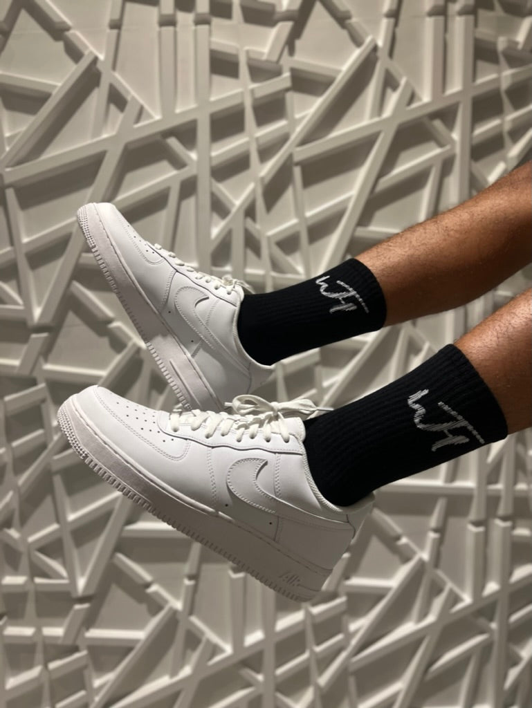 Model wearing Black Everyday Socks, with Nike Air Forces, showing white WTH Logo