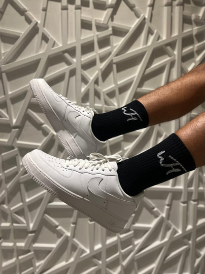 Model wearing Black Everyday Socks, with Nike Air Forces, showing white WTH Logo